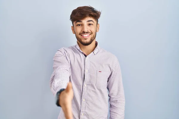 髭を生やしたアラブ人男性は 挨拶や歓迎として握手を提供する優しい笑顔の背景に立っています 成功したビジネス — ストック写真