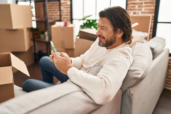 Homme Âge Moyen Utilisant Smartphone Assis Sur Canapé Nouvelle Maison — Photo