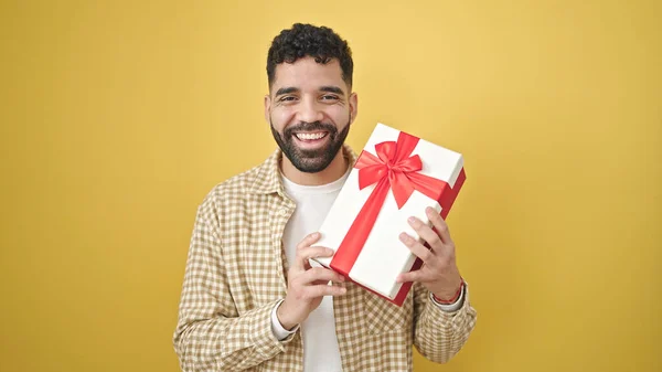 Jovem Hispânico Homem Sorrindo Confiante Segurando Presente Sobre Isolado Amarelo — Fotografia de Stock