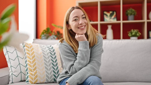 stock image Young blonde woman smiling confident sitting on sofa at home