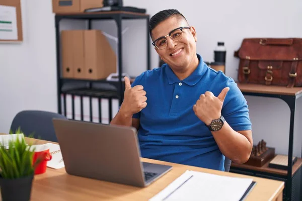 年轻的他的惊慌失措的男人在办公室里用笔记本电脑成功地签名做着积极的手势 竖起大拇指微笑着 快乐地工作着 快乐的表达和胜利的姿态 — 图库照片