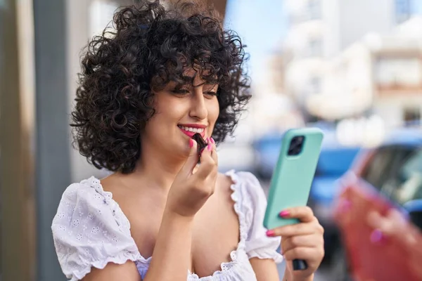 stock image Young middle east woman makeup lips looking smartphone at street