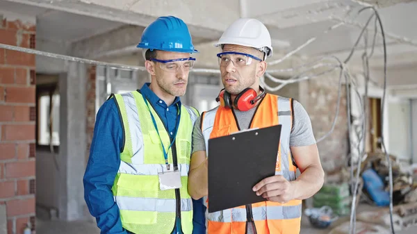 Two Men Builders Reading Document Speaking Construction Site — Stock Photo, Image