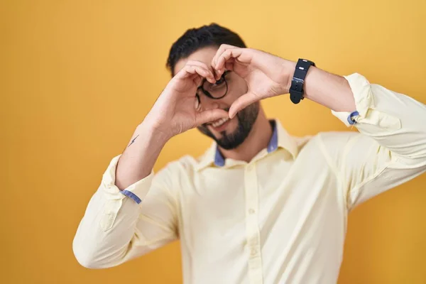 Joven Hispano Usando Ropa Negocios Gafas Haciendo Forma Corazón Con —  Fotos de Stock