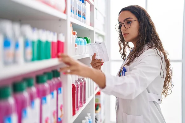 stock image Young beautiful hispanic woman pharmacist reading prescription at pharmacy