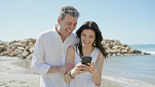 Kıdemli Erkek Kadın Çift Deniz Kenarında Akıllı Telefon Kullanarak Gülümsüyor — Stok fotoğraf