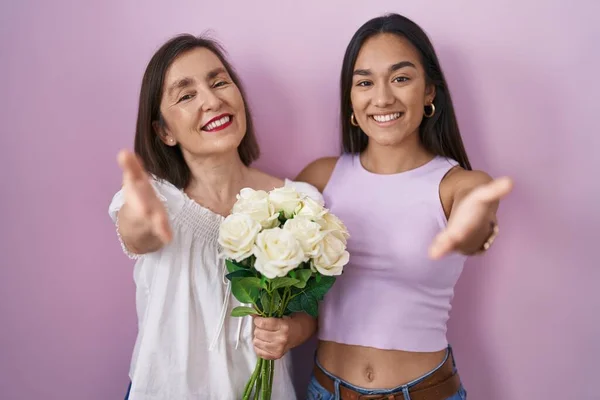 Hispanic Mother Daughter Holding Bouquet White Flowers Smiling Friendly Offering — Stock Photo, Image