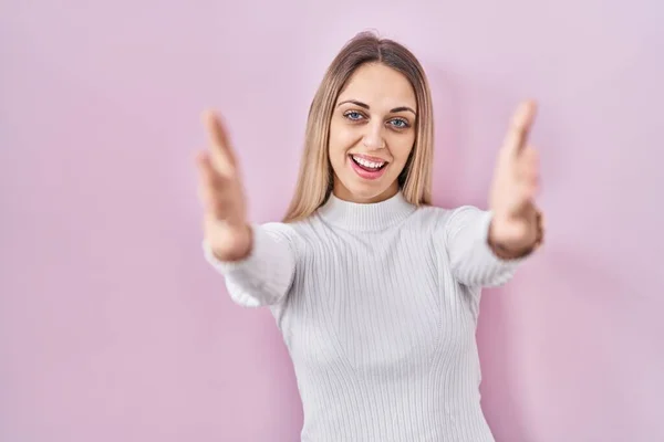 Young Blonde Woman Wearing White Sweater Pink Background Looking Camera — Stock Photo, Image