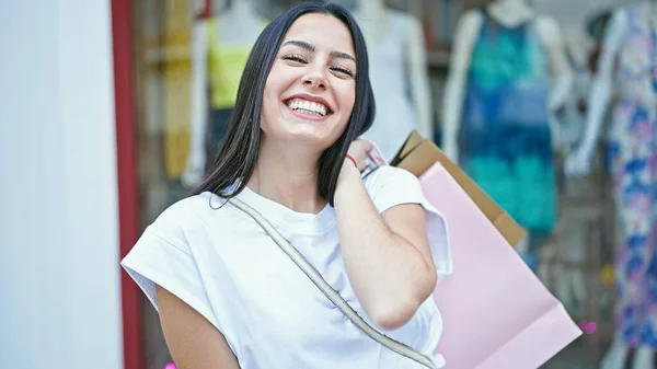 年轻美丽的惊慌失措的女人笑着带着购物袋去服装店买东西 — 图库照片