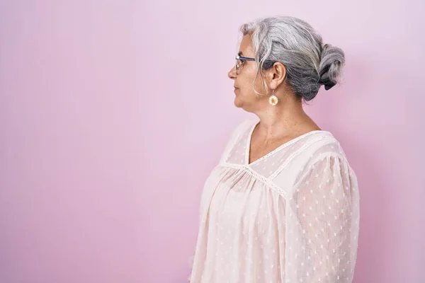 Žena Středního Věku Šedými Vlasy Stojící Nad Růžovým Pozadím Hledá — Stock fotografie
