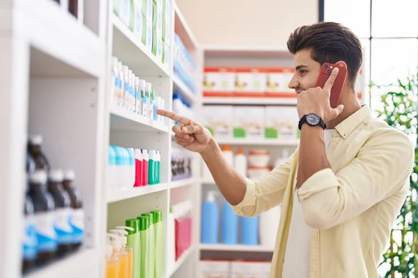 Молодой Латиноамериканец Клиент Улыбается Уверенно Разговаривая Смартфоне Аптеке — стоковое фото