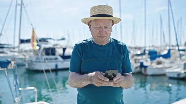 Starszy Siwowłosy Mężczyzna Turysta Noszenie Letni Kapelusz Pomocą Smartfona Porcie — Zdjęcie stockowe
