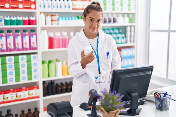 Молодая Красивая Латиноамериканка Фармацевт Помощью Компьютера Держит Бутылку Таблетками Аптеке — стоковое фото