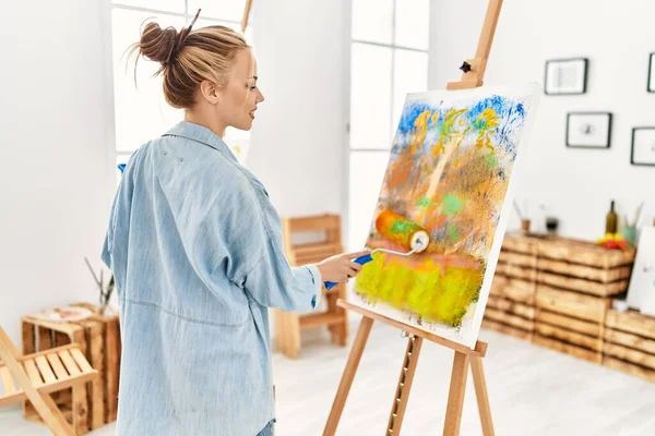 若い白人女性アーティストがアートスタジオで絵の具ローラードローイングを使って — ストック写真