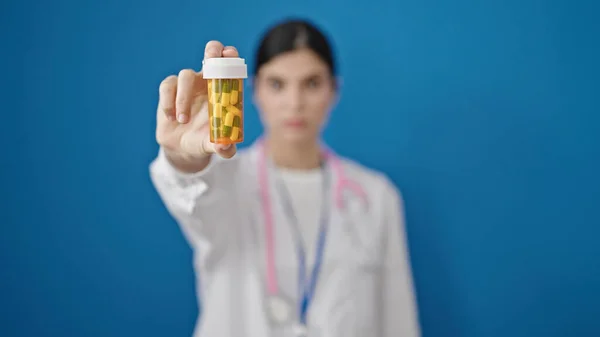 Mladá Krásná Hispánská Žena Lékař Drží Pilulky Přes Izolované Modré — Stock fotografie