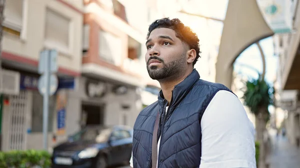 stock image African american man looking to the side with serious expression at street