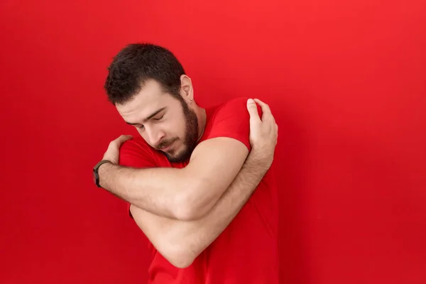 Young Hispanic Man Wearing Casual Red Shirt Hugging Oneself Happy — Zdjęcie stockowe