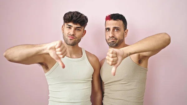 Két Férfi Pár Csinál Negatív Jel Hüvelykujjával Lefelé Izolált Rózsaszín — Stock Fotó