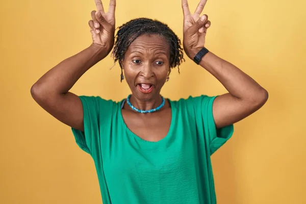 Afričanka Dredy Stojí Nad Žlutým Pozadím Pózuje Legrační Šílený Prsty — Stock fotografie