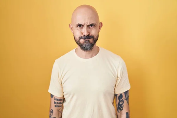 Homem Hispânico Com Tatuagens Sobre Fundo Amarelo Soprando Bochechas Com — Fotografia de Stock