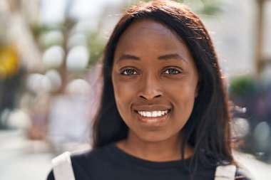 Genç Afrikalı Amerikalı kadın gülümsüyor. Kendine güveni tam.