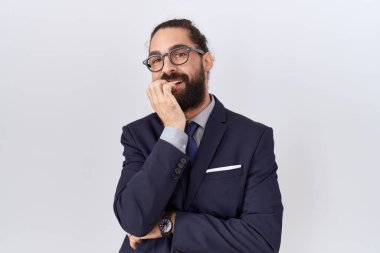 Sakallı, takım elbiseli ve kravatlı İspanyol bir adam gergin ve elleri ağızdan tırnak yerken gergin görünüyor. anksiyete. 