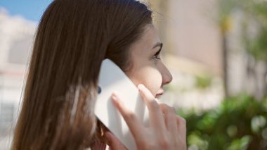 Young beautiful hispanic woman smiling confident talking on smartphone at park