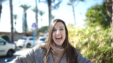 Güzel İspanyol kadın parkta kendinden emin gülümsüyor.