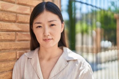 Sokakta duran rahat yüzlü Çinli kadın.