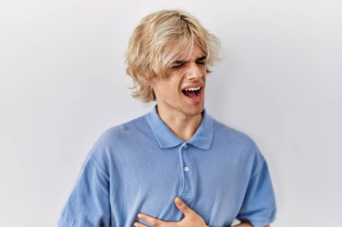 Genç ve modern bir adam midesi üzerinde el üstünde duran izole bir arka planda duruyor çünkü hazımsızlık, acı verici bir hastalık kendini iyi hissetmiyor. Ağrı kavramı. 