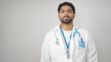 İzole edilmiş beyaz arka plan üzerinde ciddi bir ifadeyle duran Afrikalı Amerikalı doktor.