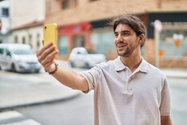 Latin asıllı genç adam gülümsüyor.