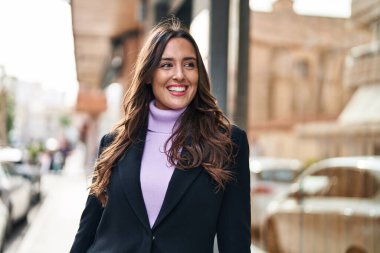 Sokakta kendine gülen genç İspanyol kadın.