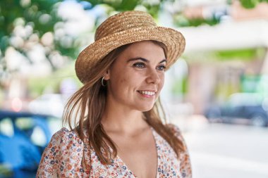 Young woman tourist wearing summer hat looking to the side at street