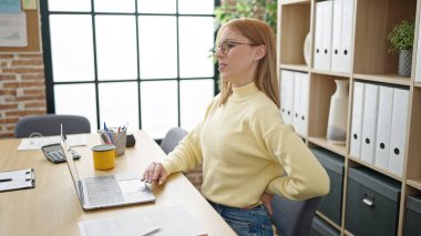 Young blonde woman business worker suffering for backache at office