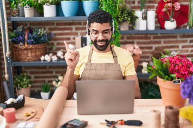 Çiçekçide çalışan sakallı İspanyol bir adam. Video çekiyor. Gülümsüyor. 