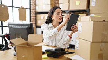 Genç, güzel, İspanyol bir kadın. İş kadını. Ofisteki dokunmatik kağıda yazıyor.