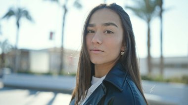 Sokakta ciddi bir ifadeyle duran genç, güzel İspanyol kadın.