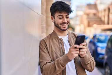 Sokakta akıllı telefon kullanan, kendine güvenen genç bir İspanyol.