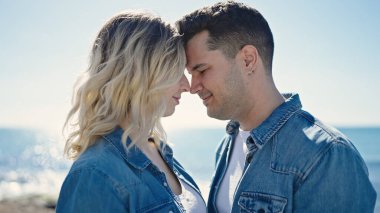 Erkek ve kadın bir arada durarak gülümsüyor.