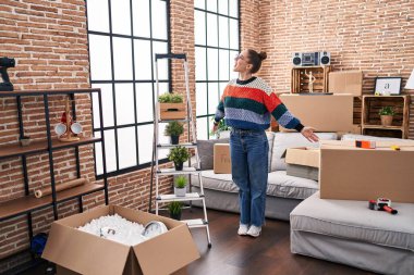 Young woman standing with arms open at new home