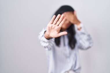 Gözlük takan genç İspanyol kadın elleriyle gözlerini kapatıyor ve üzgün ve korku ifadeleriyle jest yapıyor. utangaç ve olumsuz kavram. 