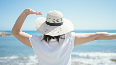 Orta yaşlı İspanyol turist kumsalda kollarını açmış bekliyor.