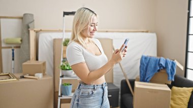 Yeni evinde akıllı telefon kullanan güzel bir İspanyol kadın.