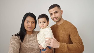 Çift ve oğul, izole edilmiş beyaz arka planda rahat bir ifadeyle birbirlerine sarılıyorlar.