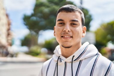 Sokakta kendine güvenen genç adam gülümsüyor