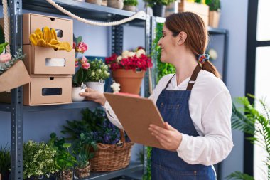 Çiçekçi dükkanında kendine güvenen genç bir çiçekçi.