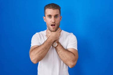 Mavi arka planda dikilen genç beyaz adam boğularak öldü diye bağırıyor. Sağlık problemi. Boğulma ve intihar konsepti. 