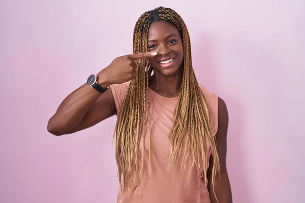 Африканская Американка Плетеными Волосами Стоящая Розовом Фоне Указывая Пальцем Руки — стоковое фото