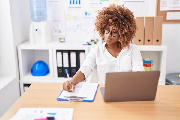 アフリカ系アメリカ人の女性ビジネスワーカーがオフィスでノートパソコンで文書を書く — ストック写真